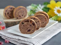 several pieces of bread on a white plate with flowers in the backgroung