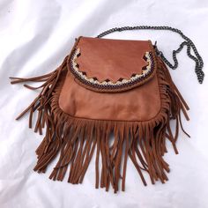 The perfect size for all of your essentials- without being too bulky or too bland- this little leather bag will be your new favorite all year long. It's adorned with beautifully detailed bead work and edged in a fun fringe, and has an inner pocket to hold your cash and cards. As versatile as it is beautiful, it also comes with two detachable straps: one leather to make it a crossbody purse, and one chain to make it a shoulder purse. Or forgo a strap altogether, and use it as a clutch! Leather Fringe Purse, Fringe Purse, Bead Leather, Leather Fringe, Shoulder Purse, Crossbody Purse, Leather Purse, Leather Working, Things To Buy