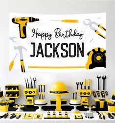 a birthday party with yellow and black decorations, construction themed items and a happy birthday banner