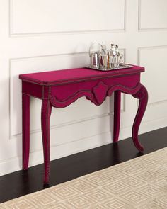 a pink table with two silver trays on it's top and bottom shelf