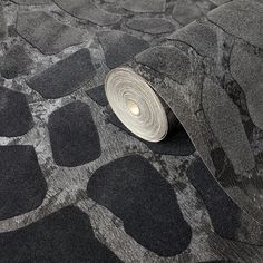 a roll of silver foil sitting on top of a black and white carpeted floor