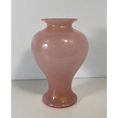 a pink vase sitting on top of a white table