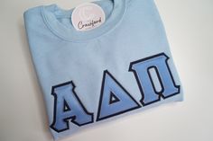 READ ME! Please allow 2-3 week shipping as all shirts are custom made. Shipping is already included for your convenience. Picture Features 1. Alpha Delta Pi - Light Blue Crewneck | Background Fabric: Navy | Top Fabric Columbia Blue 2. Alpha Chi Omega - Black Crewneck | Background Fabric: Old Gold | Top Fabric Red  There are 4 parts to your Greek Letter Shirt 1. Sweatshirt/Hoodie Color 2. Sweatshirt/Hoodie Size 3. Background Fabric 4. Top Fabric 5. Greek Organization - MAX 3 Greek letters (please contact us for 3+) CUSTOMIZE: Feel free to message me - I love custom orders. STAYING CONNECTED: If you're looking for more, visit my shop: www.thecrawfordconcept.com Do you want a first look at new designs/products and behind the scenes. Follow me! Instagram: @shopthecollegiateconcept TikTok: @sho Sorority Stitched Letters, Sorority Letter Shirts, Sorority Shirts Letters, Light Blue Crewneck, Greek Letter Shirts, Stitch Sweatshirt, Letter Shirt, Sorority Letters, Fabric Navy