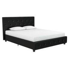 a bed with white pillows and black headboard