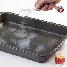 a person is sprinkling sugar on a pan