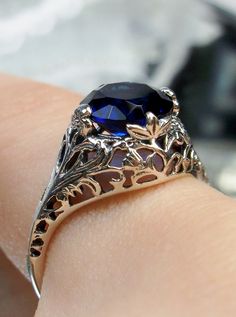 Simulated Blue Sapphire Ring  Coffee Design#198 This is a stunning Art Nouveau reproduction in sterling silver filigree with a 2ct Simulated Blue Sapphire stone. The flawless Simulated Blue Sapphire is 8mm in diameter. The inside of the band is marked 925 for sterling. Notice the beautiful craftsmanship of the silver filigree setting and band. This is a ornate and detailed ring. This is a lovely rendition of an antique filigree ring; and it is ready to wear. A gift ring box is included for safek Leaf Filigree, Sapphire Antique Ring, Victorian Ring, Antique Filigree, Art Nouveau Floral, Sapphire Solitaire, Ruby Engagement Ring, Victorian Rings, Detailed Ring