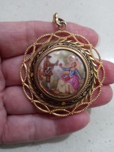 Vintage ceramic and gold tone pendant with an Edwardian courting couple. A lot of detail went into the making of this beautiful piece of jewelry. There are scratches on the backside of pendant. Please refer to pictures. Measures 1.75 inches across. Will ship within United States only. Free shipping. Iolite Necklace, Painting Old, Hammered Necklace, Dog Clip, Old World Style, Culver City, Greek Key, Quartz Necklace, Boulder Opal