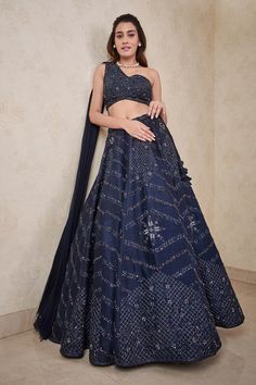 Navy blue dupion silk lehenga with an attached cancan and crystals hand embroidery. Comes with a padded one-shoulder blouse with an attached georgette dupatta. Components: 2 Pattern: Hand embroidered Type Of Work: Crystals Neckline: One Shoulder Sleeve Type: Sleeveless Fabric: Dupion silk, Attached dupatta : Georgette Color: Blue Other Details:  Attached lining Lehenga length : 43 inches Closure : Lehenga - Drawstrings Occasion: Destination Wedding - Aza Fashions One Shoulder Blouse With Attached Dupatta, Bronze Lehenga, One Shoulder Blouse Lehenga, One Shoulder Lehenga, Work Crystals, Aesthetic Bookmarks, Navy Blue Lehenga, Sangeet Outfit, Haldi Outfit