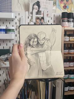 a drawing of spider - man and woman hugging each other in front of some art supplies