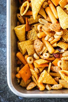 a metal container filled with cheetos and nuts