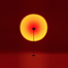 a red and yellow light in the middle of a room with a floor lamp on it