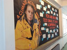 a woman is standing in front of a poster on the wall that says climate acting matters