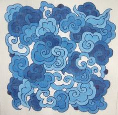 a cross stitch pattern with blue swirls in the center and white background, on a piece of cloth