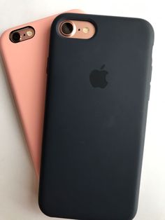 two iphones sitting next to each other on a white surface, one is pink and the other is black