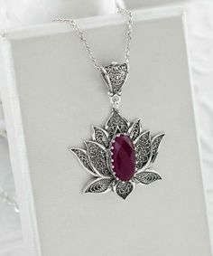 Introducing our stunning handcrafted filigree art blossoming lotus flower figured pendant necklace, featuring a breathtaking ruby corundum gemstone. This elegant necklace is made of high-quality 925 sterling silver and measures 20 inches in length, with a pendant height of 1.70 inches and a width of 1.20 inches. The July birthstone ruby corundum gemstone is a faceted oval cut that measures 7.00x14.00 mm, adding a touch of luxury to this already exquisite piece. Each necklace comes with a silver Teardrop Pendant Necklace With Intricate Design For Gift, Intricate Teardrop Pendant Necklace As Gift, Elegant Lotus Flower Jewelry Gift, Exquisite Gemstone Flower Pendant Necklace, Ornate Ruby Jewelry Gift, Ornate Ruby Jewelry As A Gift, Ornate Ruby Jewelry For Gifts, Exquisite Ruby Gemstone Necklace, Exquisite Ruby Pendant Necklace