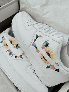 a white nike air force with sunflowers painted on the upper and bottom part