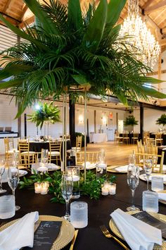 a table is set with place settings, candles and greenery for an elegant wedding reception