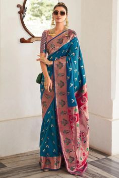 Turn heads in the captivating Teel Blue Paithani Silk Saree, a timeless embodiment of Indian tradition. This exquisite saree is adorned with delicate motifs, exuding an aura of refinement and grandeur. The intricately woven traditional Paithani Border and Pallu add a touch of opulence, lending a regal and ethereal look. Elevate your ethnic wardrobe and experience the joy of draping a saree that celebrates Indian elegance and femininity. Occasion: Wedding Wear, Party Wear, Festive Wear, Engagemen Blue Silk Saree, Paithani Saree, Silk Weaving, Fancy Wedding, Blue Saree, Art Silk Sarees, Wear Saree, Work Sarees, Azure Blue