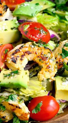 a salad with shrimp, avocado and tomatoes