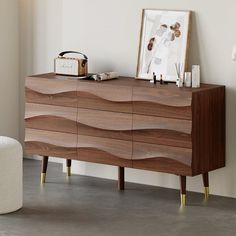 a wooden dresser sitting next to a white chair