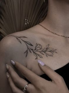 a woman's arm with a leaf tattoo on the left side of her body