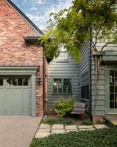 a brick house with green doors and windows