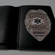 an emergency medical service paramedic badge is shown on a black leather wallet,