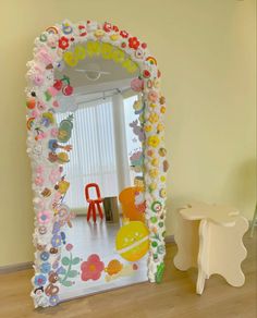 a child's room with a large mirror and toys on the floor in front of it