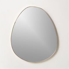 an oval mirror on the wall with a gold rim around it and a white background