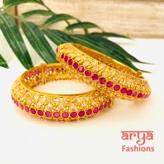 Golden Ruby Pink Polki Kada, Pair of 2 Bangles Features: Made in brass with Polki stones and Ruby pink kemp stones 22 Karat Gold finish Pair of 2 Bangles Thickness: Approx. 0.85 Inches Available in size 2.6,2.8 Openable Bangles Can fit one size up due to openable feature Screw based opening Polki Kada, Gold Finish, Screw, Ruby, Bangles, Size 2, Brass, Stone, Pink