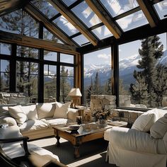 a living room filled with lots of furniture under a skylight covered in snow capped mountains