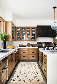 a kitchen with wooden cabinets and an area rug on the floor in front of it