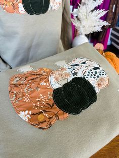 two pillows with appliqued pumpkins on them are sitting on a table