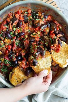 a person is holding bread with black beans and tomatoes