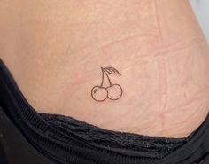 small cherries tattoo on the back of a woman's lower body, with one cherry still attached