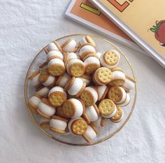 a plate full of crackers and marshmallows on a table next to a book