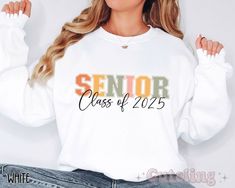 Retro colors Senior 2025 sweatshirt, featuring college style lettering of the word "SENIOR" and the graduation year. ♥ Soft and comfy cotton blend crewneck sweatshirt. ♥ Our shirts are printed using a high end DTG (Direct to Garment) printer that uses water-based inks which are absorbed into the fabric, creating a smooth finish on the shirt, that won't fade or peel off (no vinyl!). ♥ MADE TO ORDER - Please allow 2-6 business days for this item to be made and prepared for shipping. ♥ Go back to m White Letter Embroidery Sweatshirt For School, White School Spirit Sweatshirt For College, White College Sweatshirt With School Spirit, Fall Letter Print Sweatshirt For College Events, White Varsity Sweatshirt For School, White T-shirt With Letter Embroidery For College, White Tops With Letter Embroidery For School, School Spirit Sweatshirt With Letter Print For College Events, White School Spirit Sweatshirt For Campus