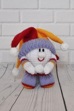 a knitted snowman with a red and yellow hat on it's head