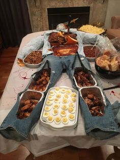 a table topped with lots of food covered in blue cloths and bowls filled with eggs