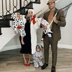 a man and woman in dalmatian costumes standing next to a baby on the floor