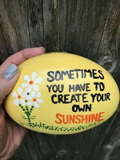 someone holding up a painted rock that says, sometimes you have to create your own sunshine