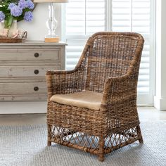 a wicker chair sitting in front of a dresser