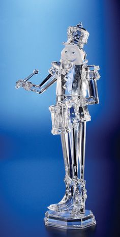 a crystal figurine is standing in front of a blue background