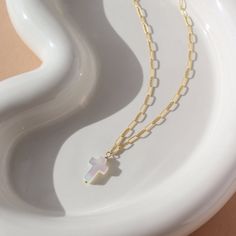 Add a touch of elegance and spirituality to your outfit with our Mother of Pearl Cross Necklace. This unique piece features a stunning cross-shaped charm made from mother of pearl, symbolizing purity and protection. The delicate cosette chain completes the look, making it perfect for any occasion. DETAILSAvailable in 16" or 18" lengthsAvailable in 14k Gold Fill and Sterling SilverHypoallergenic and nickel freeWe recommend removing pearls before showering, swimming or sleeping to keep them shinin Cross Pendant Necklace With Pearl Charm, White Cross Pendant Necklace With Clavicle Chain, White Cross Necklace With Clavicle Chain, White Cross Necklace With Pearl Pendant, White Cross Necklace With Pearl Charm, Gift Pearl Pendant Cross Necklace, Cross Necklace With Pearl Charm, Gift Cross Necklace With Pearl Pendant, White Cross Necklace With Adjustable Chain