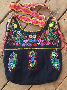 "This is a beautiful embroidered bag handmade by Mexican Artisans With elegant multi-colored designs and patterns Each embroidered bag takes about 10 hours to make Straps are made with macrame technic The strap is long enough to wear as a simple over the shoulder or as a crossbody Every bag is unique made with ancestral techniques Excellent gift for any occasion Due to the hand made nature of this item the embroidered colors and patterns may vary **HAND WASH ONLY** Follow and tag us on instagram Multicolor Floral Embroidered Shoulder Bag For Travel, Multicolor Floral Embroidery Shoulder Bag For Travel, Rectangular Bag With Multicolor Embroidery And Hand-stitched Details, Hand-stitched Rectangular Bag With Multicolor Embroidery, Handmade Multicolor Embroidered Hobo Bag For Everyday Use, Handmade Multicolor Embroidery Hobo Bag For Everyday Use, Embroidered Rectangular Hobo Bag For Festivals, Artisan Bags With Multicolor Embroidery For Everyday Use, Handmade Multicolor Embroidery Hobo Bag