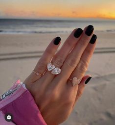 a woman's hand with two rings on the beach