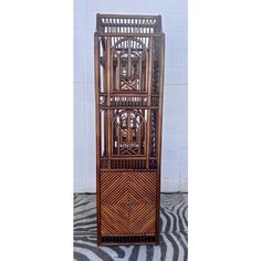 a tall wooden shelf with an intricate design on the top and bottom section, sitting on a zebra print rug