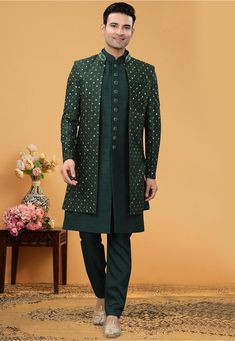 Art Silk Sherwani in Dark Green This Readymade attire is Enhanced with Buttons, Resham and Stone Work. Crafted in Chinese Collar Neck and Full Sleeve Available with an Art Silk Pant in Dark Green and an Art Silk Long Jacket in Dark Green Do note: Bottom Style and Footwear shown in the image is for presentation purposes only. Half to one inch may vary in measurement. (Slight variation in actual color vs. image is possible) Bottle Green Sherwani For Men, Green Indo Western Outfits, Western Outfits For Men, Indo Western Outfits For Men, Indian Wedding Clothes For Men, Indo Western Sherwani, Sherwani Groom, Sherwani For Men, Kurta Men