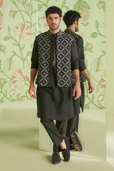 Black cotton silk Mughal jaali embroidered bundi. Paired with embroidered placket kurta and pant.
Component: 3
Pattern: Embroidered
Type Of Work: Thread work
Neckline: Mandarin collar
Sleeve Type: Full sleeves
Fabric: Cotton silk
Color: Black
Other Details: 
Button placket bundi
Note: Bundi kurta set worn by the model on the left is not for sale
Occasion: Reception - Aza Fashions Traditional Designer Outerwear For Transitional Season, Black Nehru Jacket With Zari Work For Festivals, Traditional Black Outerwear With Chikankari Embroidery, Black Nehru Jacket With Zari For Festivals, Festive Black Outerwear With Chikankari Embroidery, Festive Black Outerwear With Intricate Embroidery, Black Nehru Jacket With Zari Work For Designer Wear, Black Resham Embroidered Outerwear For Festive Occasions, Festive Traditional Outerwear With Chikankari Embroidery