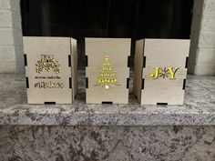 three wooden christmas cards sitting on top of a mantle